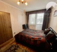 Vám ponúka 3-izbový byt s loggiou po kompletnej - Spálňa v 3-izbovom byte s podlahou s dreveným dekorom, veľké okno, posteľ.