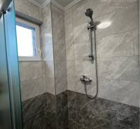 Vám ponúka na PREDAJ kompletne zrekonštruovaný  - Sprchový kút v rodinnom dome s mramorovým obkladom a modernou sprchovou hlavicou.