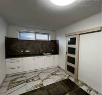 Vám ponúka na PREDAJ kompletne zrekonštruovaný  - Kuchyňa v Rodinnom dome s dlažbou mramorového vzoru a svetlým zariadením.