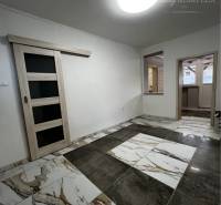 Vám ponúka na PREDAJ kompletne zrekonštruovaný  - Interiér rodinného domu s posuvnými dverami a podlahou s mramorovým vzorom.