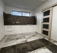 Vám ponúka na PREDAJ kompletne zrekonštruovaný  - Interiér v rodinnom dome s dlažbou a kuchynským kútom v jemných farbách.