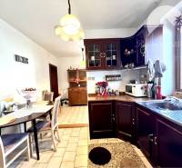 Ponúka na PREDAJ zrekonštruovaný 5 izbový podpi - Kuchyňa s jedálňou v rodinnom dome s dreveným nábytkom a keramickou dlažbou.