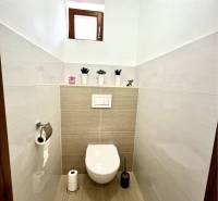 Ponúka na PREDAJ zrekonštruovaný 5 izbový podpi - Toaleta s oknom v rodinnom dome, neutrálne obklady a podlaha.