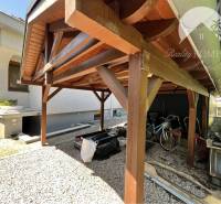 Ponúka na PREDAJ zrekonštruovaný 5 izbový podpi - Drevený prístrešok vedľa rodinného domu v Topoľníkoch so skladom a bicyklami.