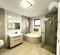 Ponúka na PREDAJ zrekonštruovaný 5 izbový podpi - Kúpeľňa v rodinnom dome s vaňou, sprchou a elegantným obkladom.