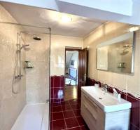 Ponúka na PREDAJ zrekonštruovaný 5 izbový podpi - Kúpeľňa v rodinnom dome s dlažbou, sprchovým kútom a umývadlom.