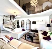 Ponúka na PREDAJ zrekonštruovaný 5 izbový podpi - Obývacia izba v rodinnom dome so špirálovitým schodiskom a elegantným osvetlením.