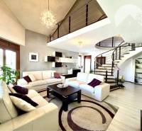 Ponúka na PREDAJ zrekonštruovaný 5 izbový podpi - Obývacia izba v rodinnom dome so špirálovým schodiskom a bielym nábytkom.