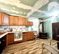 Ponúka na PREDAJ viničný domček s priestranným  - Kuchyňa v chate s drevenými skrinkami, sporákom a dlažbou.