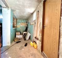 Ponúka na PREDAJ viničný domček s priestranným  - Úložná miestnosť v Chate s nástrojmi a drevenými dverami, ktorá potrebuje úpravu.