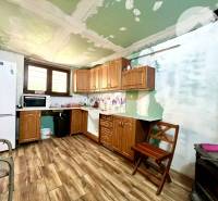 Ponúka na PREDAJ viničný domček s priestranným  - Kuchyňa v chate s dreveným nábytkom, podlahou a spotrebičmi.