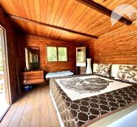 Ponúka na PREDAJ viničný domček s priestranným  - Drevený interiér chaty s pohodlnou posteľou a drevenou podlahou.
