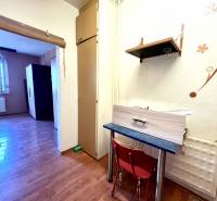 Ponúka na PREDAJ 1 izbový byt v Komárne - 1-izbový byt s podlahou s dreveným dekorom, nábytok a dekorácie na stene.