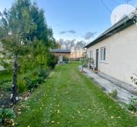 Investičný pozemok s obývateľným domom vo Vrakúni - Rodinný dom vo Vrakúni s udržiavanou záhradou, popri dome vedie chodník.