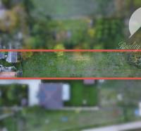 Investičný pozemok s obývateľným domom vo Vrakúni - Rodinný dom vo Vrakúni, obklopený zeleňou, ohraničený červeným rámom zhora.