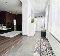 Vám ponuka na predaj útulný 3-izbový rodinný d - Interiér rodinného domu s podlahou s dreveným dekorom a vzorovaným kobercom.