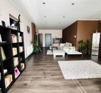 Vám ponuka na predaj útulný 3-izbový rodinný d - Obývacia izba v rodinnom dome s policami a podlahou s dreveným dekorom.