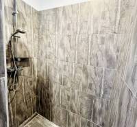 Vám ponuka na predaj útulný 3-izbový rodinný d - Kúpeľňa v rodinnom dome s moderným sprchovým kútom a keramickou dlažbou.