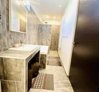 Vám ponuka na predaj útulný 3-izbový rodinný d - Kúpeľňa v rodinnom dome s dlaždicovou stenou, umývadlom a zrkadlom.