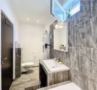 Vám ponuka na predaj útulný 3-izbový rodinný d - Kúpeľňa v rodinnom dome s keramickým obkladom a vaňou, viditeľné umývadlo a toaleta.