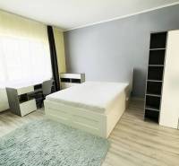 Vám ponuka na predaj útulný 3-izbový rodinný d - Svetlá izba v rodinnom dome s posteľou, písacím stolom a podlahou s dreveným dekorom.