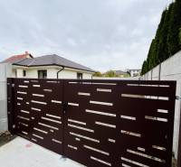 Vám ponúka na predaj moderný 4-izbový bungalov - Brána pred rodinným domom v Topoľníkoch s dizajnom horizontálnych otvorov.