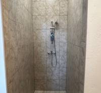 Autoservis s výbavou pre vozidlá v uzavretom priemyselnom areáli - HC - Sprchový kút s obkladmi a hlavicou v budove, jednoduchý dizajn.