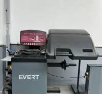 Autoservis s výbavou pre vozidlá v uzavretom priemyselnom areáli - HC - Vyvažovací stroj EVERT v budove autoservisu, vhodný na údržbu vozidiel.