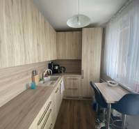 Exkluzívne v našej RK 3 izbový byt po rekonštrukcii s dvomi loggiami - Kuchyňa v 3-izbovom byte s podlahou s dreveným dekorom a svetlým nábytkom.