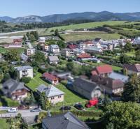 I Na predaj dvojposchodový 5i rodinný dom pri Žiline - Letecký pohľad na rodinné domy v Lietavskej Lúčke na M. Chmeliara, obklopené zeleňou a horami.