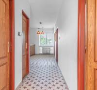 I Na predaj dvojposchodový 5i rodinný dom pri Žiline - Chodba v rodinnom dome s dlažbou, drevenými dverami a visiacimi lampami.