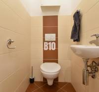 Veľkometrážny 3 izbový byt s garážou - Toaleta s umývadlom v 3-izbovom byte, obložená svetlými obkladmi.