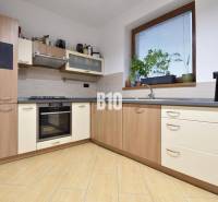 Veľkometrážny 3 izbový byt s garážou - Kuchyňa v 3-izbovom byte s rohovou linkou a podlahou s dreveným dekorom.