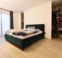 Veľkometrážny 3 izbový byt s garážou - Spálňa s posteľou, podlahou s dreveným dekorom a šatníkom v 3-izbovom byte.