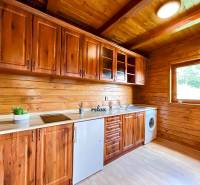 Rekreačná chata – Banská Štiavnica, časť Štefultov - Drevená kuchyňa v rodinnom dome s drevenými skrinkami a výhľadom z okna.