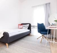 Na predaj 3 izbový dvojpodlažný byt Ivanka pri Dunaji - Spálňa v 3-izbovom byte s posteľou, okrúhlym stolom a písacím stolom s kreslom.