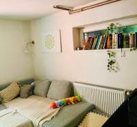 4 izbová celoročná chata v Kučišdorfskej doline na predaj - Pohodlný gauč v chate s vankúšmi, knihami a dekoráciou na stene.