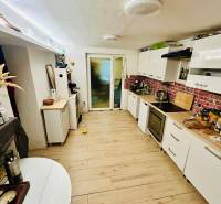 4 izbová celoročná chata v Kučišdorfskej doline na predaj - Kuchyňa v Chate s podlahou s dreveným dekorom a bielym nábytkom.