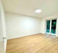 Krásny 4i byt v príjemnej lokalite BA - Izba v 4-izbovom byte s podlahou s dreveným dekorom a veľkým oknom.