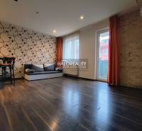 Prenájom, dvojizbový byt Dunajská Streda - Obývacia izba v 2-izbovom byte so vzorovanou tapetou a podlahou s dreveným dekorom.