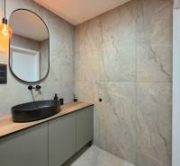 REZERVOVANÝ - Moderný 3-izbový byt po rekonštrukcii na Terase, Košice - Kúpeľňa v 3-izbovom byte s umývadlom na drevenom dekore a čiernym svietidlom.