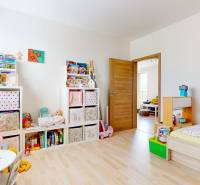 4i byt s terasou a parkovaním v tichej časti Rovinky | 89m2 - Detská izba s hračkami a nábytkom v 4-izbovom byte s podlahou s dreveným dekorom.