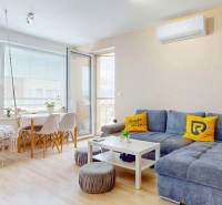 4i byt s terasou a parkovaním v tichej časti Rovinky | 89m2 - Obývacia izba v 4-izbovom byte s podlahou s dreveným dekorom, pohovkou a hojdačkou.