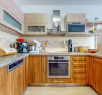 4i byt s terasou a parkovaním v tichej časti Rovinky | 89m2 - Kuchyňa v 4-izbovom byte s dreveným dekorom a modernými spotrebičmi.