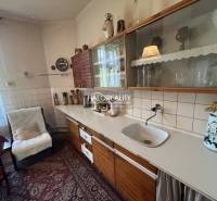 Predaj, rodinný dom Prievidza, 2 rodinné domy na 1 p... - Kuchyňa v rodinnom dome s drevenými skriňami a útulným posedením pri stole.