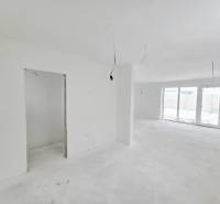 Postavíme dom aj pre Vás! Bývajte v novostavbe v Sokolovciach - Priestranný interiér rodinného domu s bielymi stenami a veľkými oknami.