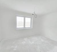 Postavíme dom aj pre Vás! Bývajte v novostavbe v Sokolovciach - Prázdna miestnosť v rodinnom dome s bielymi stenami a betónovou podlahou.