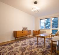 Slnečný 3-izbový byt, Kramáre - Obývacia izba s retro nábytkom, kobercom a lustrom v 3-izbovom byte.