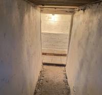 Garáž Púpavova, Karlova Ves + pivnica - Úzky priestor v pivnici na ulici s Púpavovou. Stará, biela omietka, svetlo na konci.