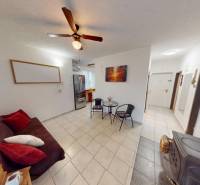 NAJLACNEJŠÍ 3- izbový byt v Topoľčanoch, neďaleko ZKW - Obývacia izba v 3-izbovom byte s dlažbou, rozkladacím gaučom a ventilátorom na strope.